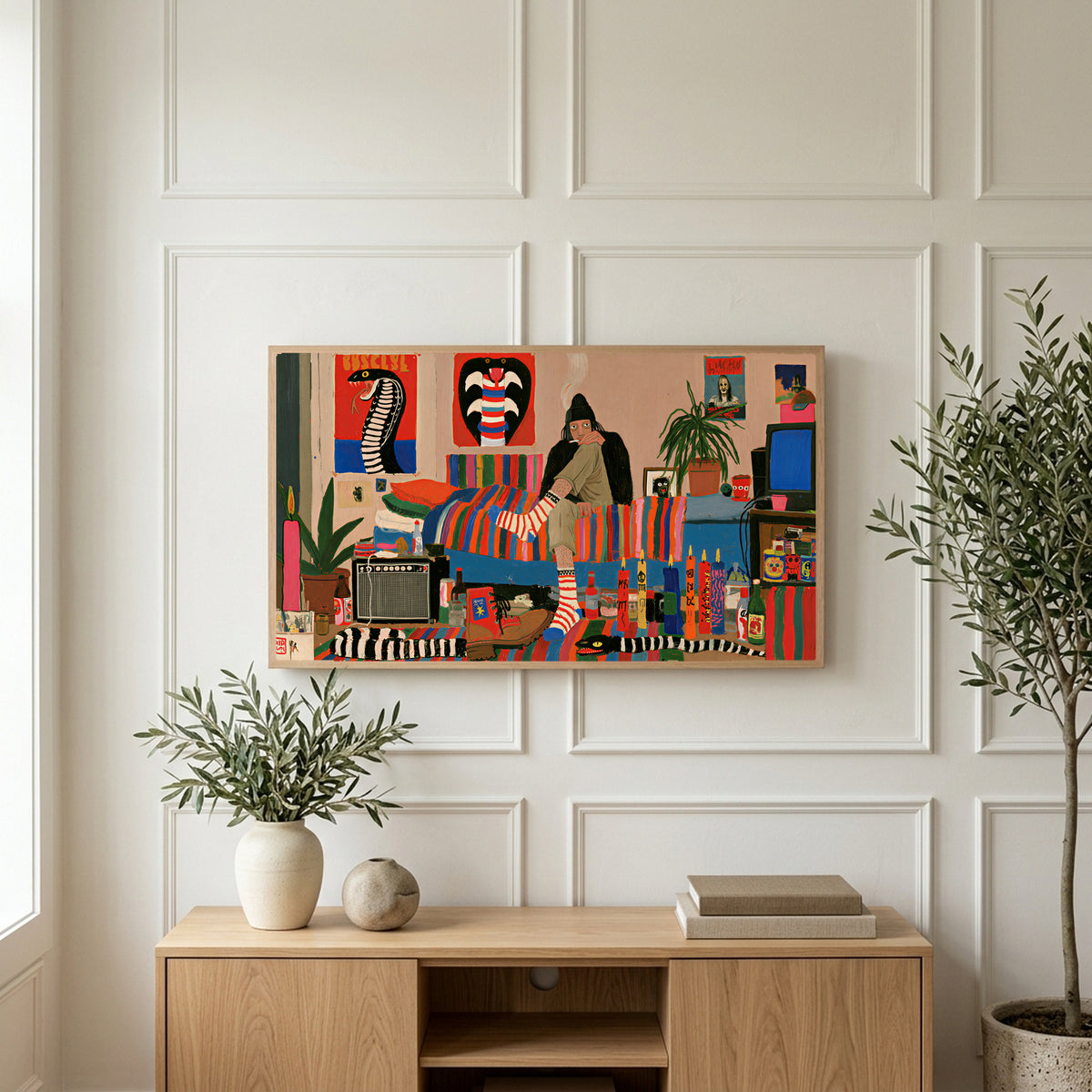 Eclectic retro room art on a TV above a light oak sideboard with olive branches in a bright living room