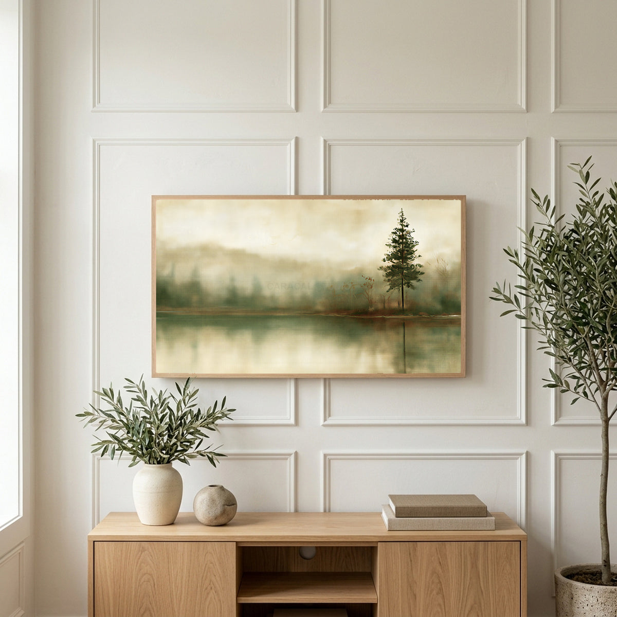 Misty lake pine art on a TV above a light oak sideboard with olive branches in a bright living room