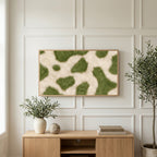 Olive cowhide art on a TV above a light oak sideboard with olive branches in a bright living room