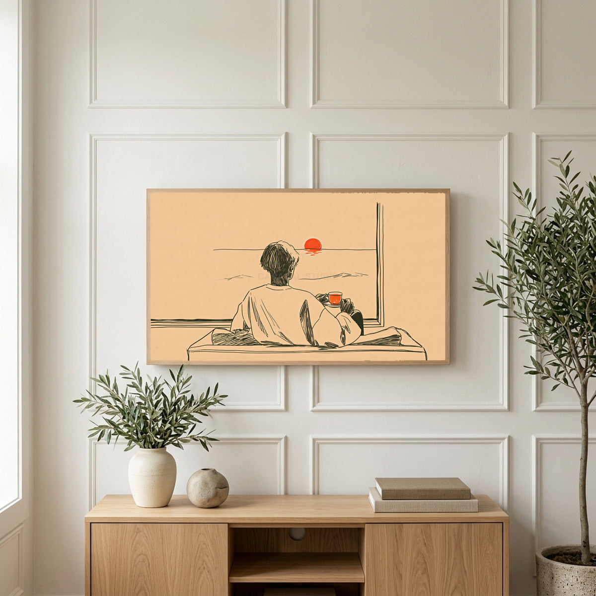 Sunset tea art on a TV above a light oak sideboard with olive branches in a bright living room
