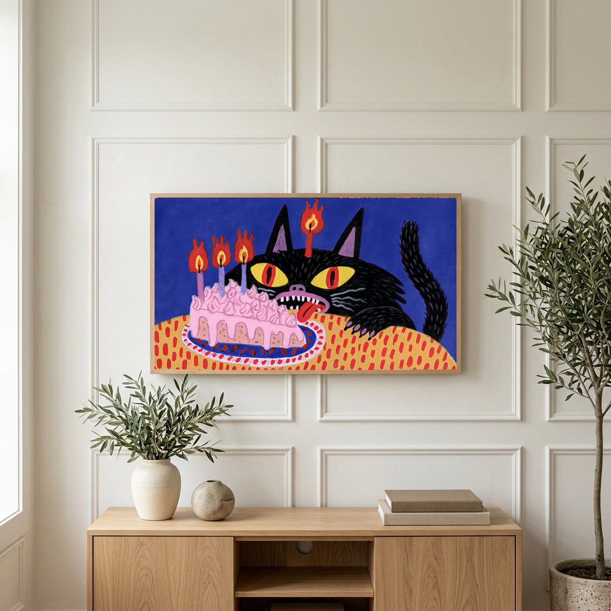 Birthday cat art on a TV above a light oak sideboard with olive branches in a bright living room