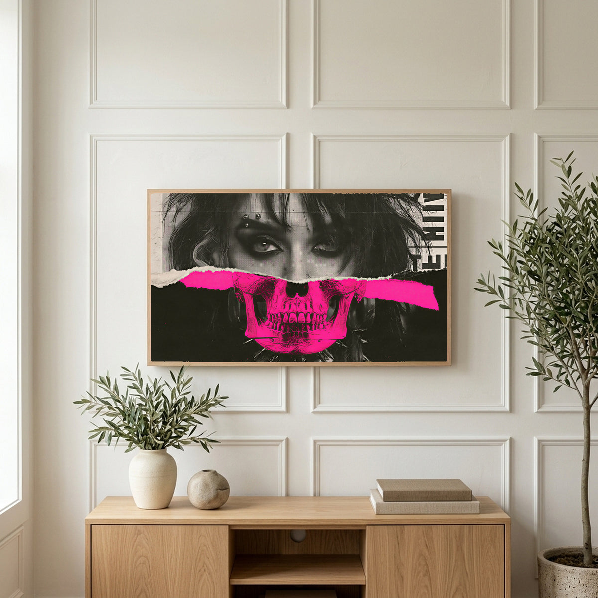 Punk skull portrait art on a TV above a light oak sideboard with olive branches in a bright living room
