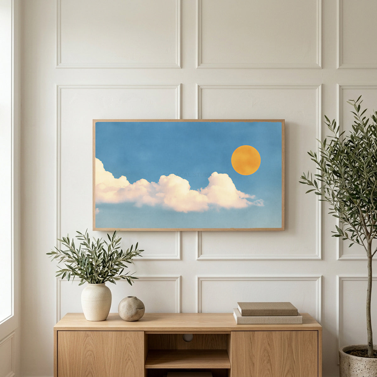 Sun and clouds art on a TV above a light oak sideboard with olive branches in a bright living room