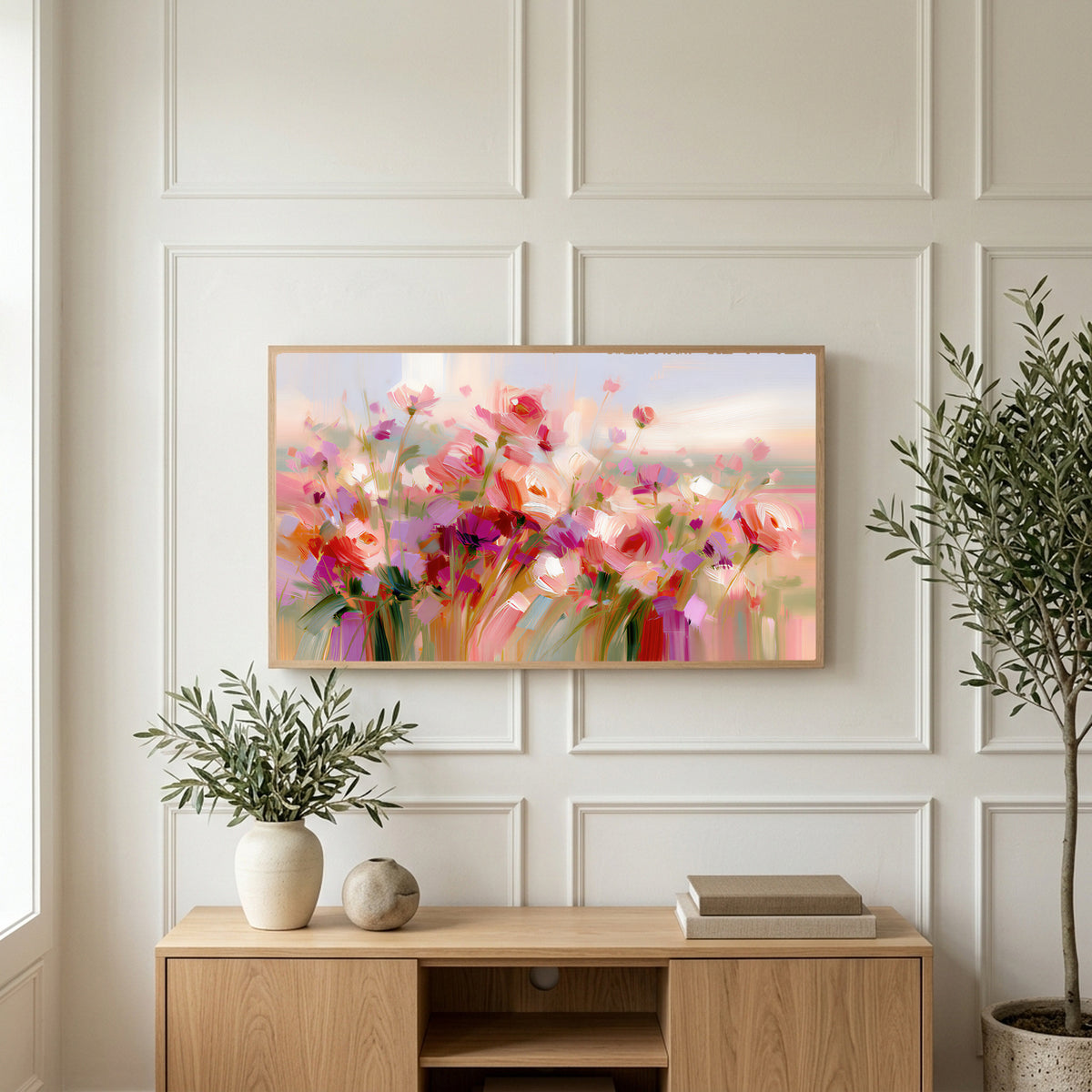 Pink wildflower meadow art on a TV above a light oak sideboard with olive branches in a bright living room