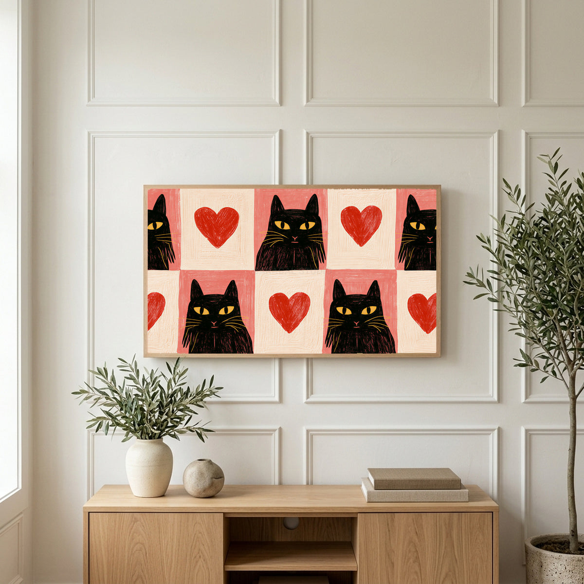 Black cat and heart art on a TV above a light oak sideboard with olive branches in a bright living room