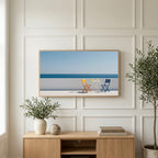 Ocean view terrace art on a TV above a light oak sideboard with olive branches in a bright living room