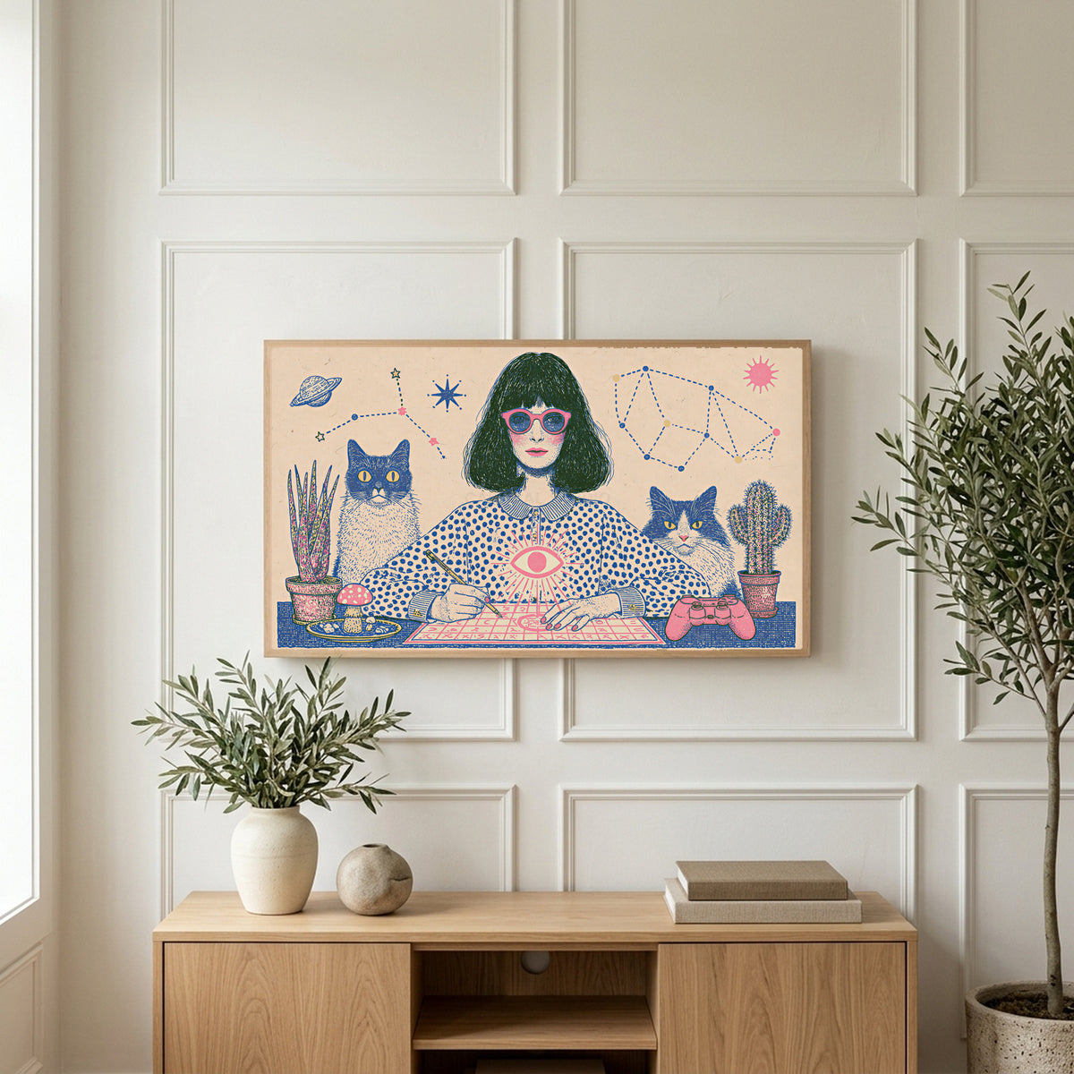 Astrology and cats art on a TV above a light oak sideboard with olive branches in a bright living room
