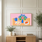 Breakfast table with flowers art on a TV above a light oak sideboard with olive branches in a bright living room