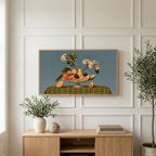 Fruit still life art on a TV above a light oak sideboard with olive branches in a bright living room