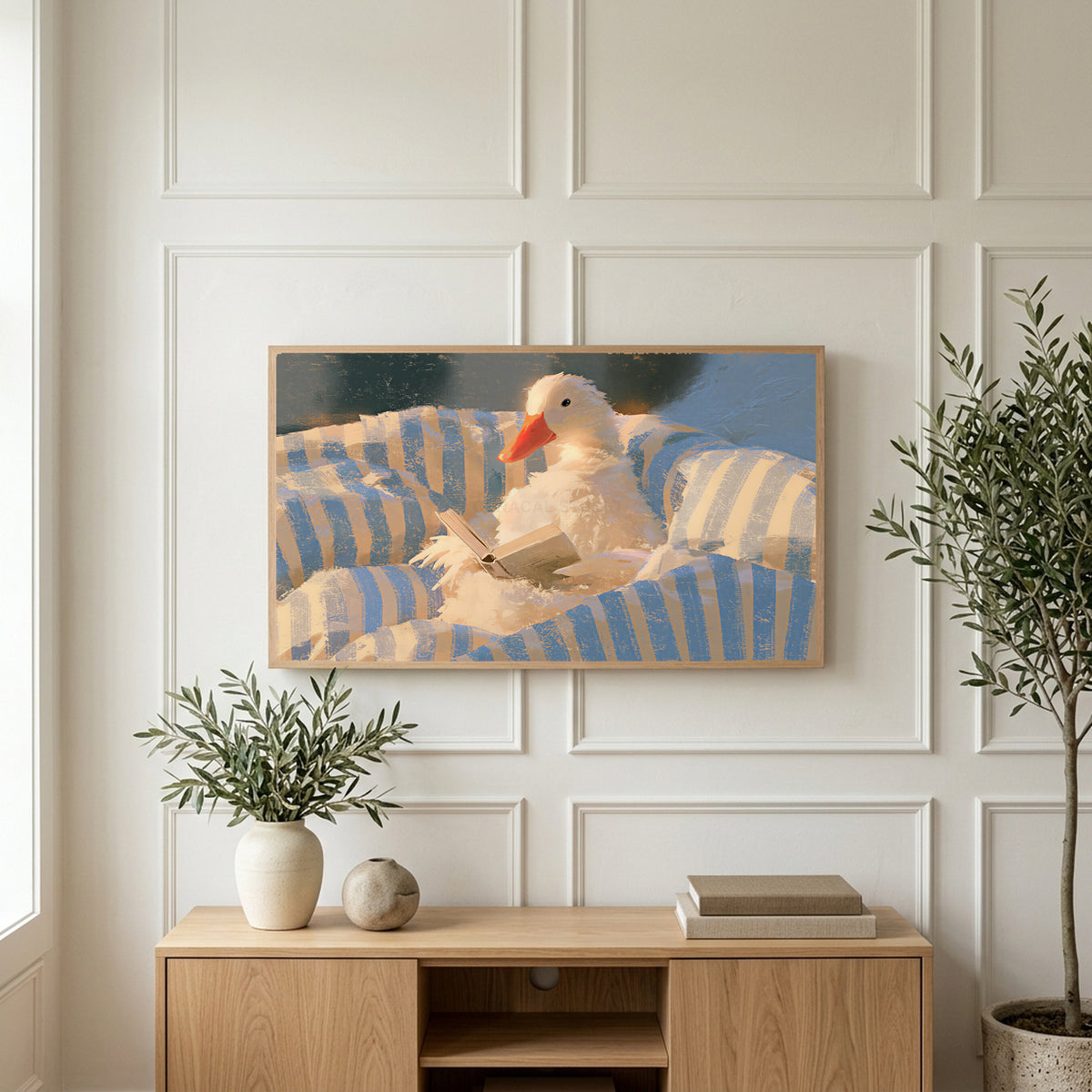 Duck reading in bed art on a TV above a light oak sideboard with olive branches in a bright living room