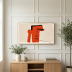 Red block face art on a TV above a light oak sideboard with olive branches in a bright living room