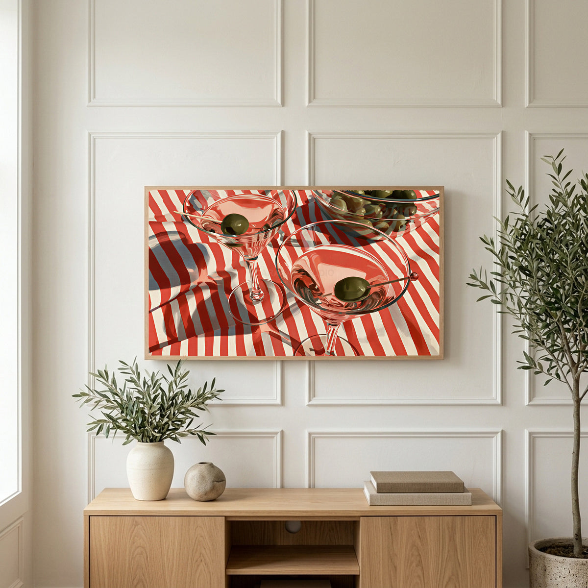 Martini cocktails art on a TV above a light oak sideboard with olive branches in a bright living room