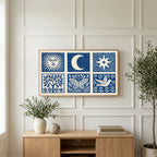 Celestial folk art on a TV above a light oak sideboard with olive branches in a bright living room