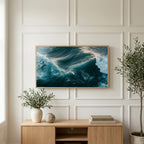 Aerial ocean waves art on a TV above a light oak sideboard with olive branches in a bright living room