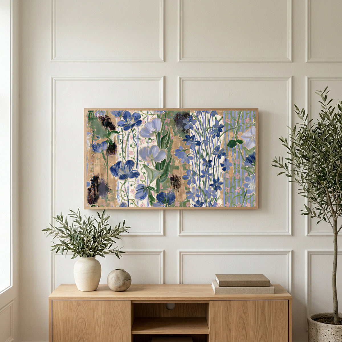 Vintage blue florals art on a TV above a light oak sideboard with olive branches in a bright living room