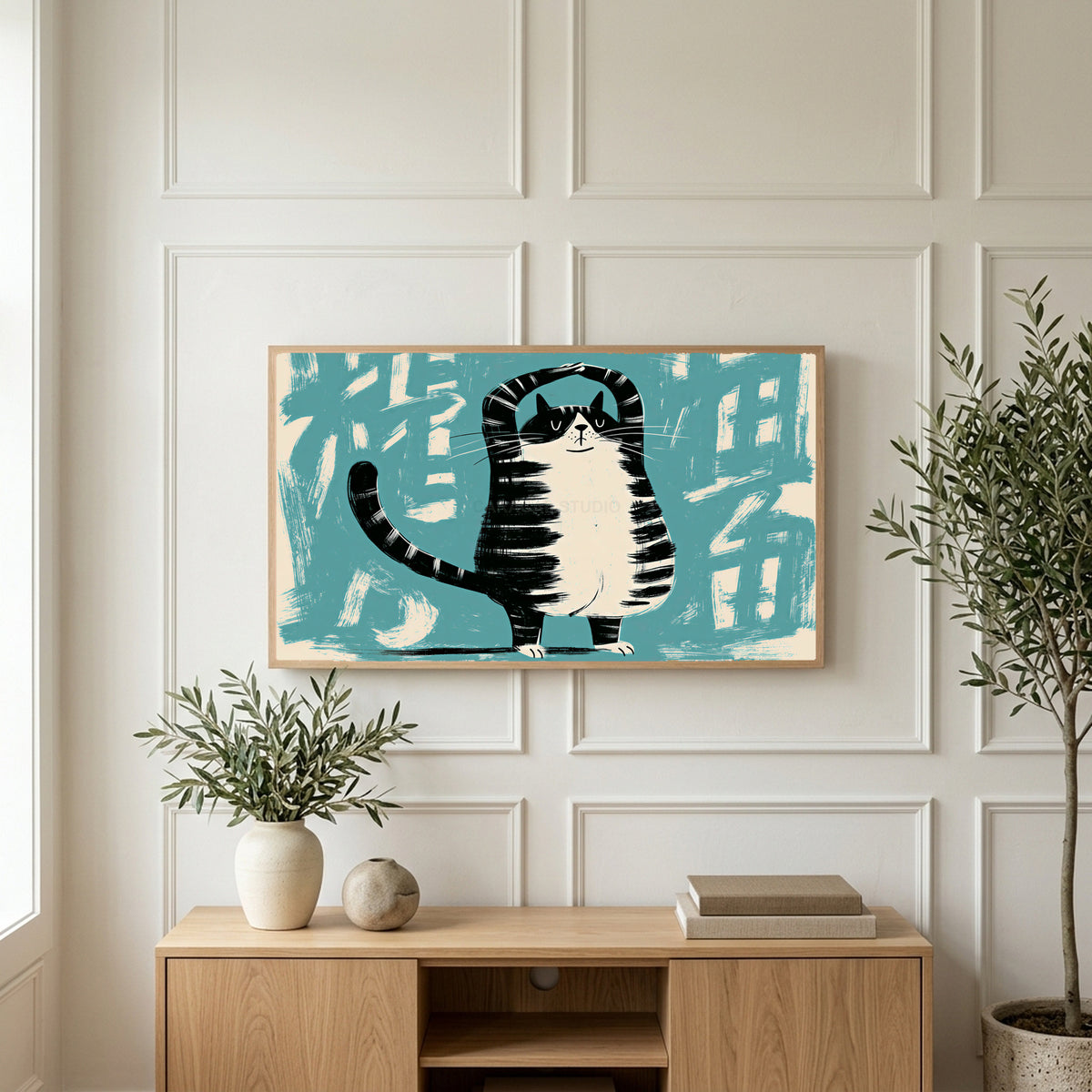 Yoga cat art on a TV above a light oak sideboard with olive branches in a bright living room