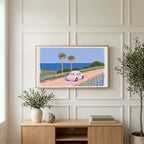 Seaside car art on a TV above a light oak sideboard with olive branches in a bright living room