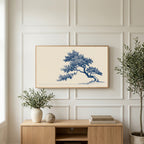 Blue ink tree art on a TV above a light oak sideboard with olive branches in a bright living room