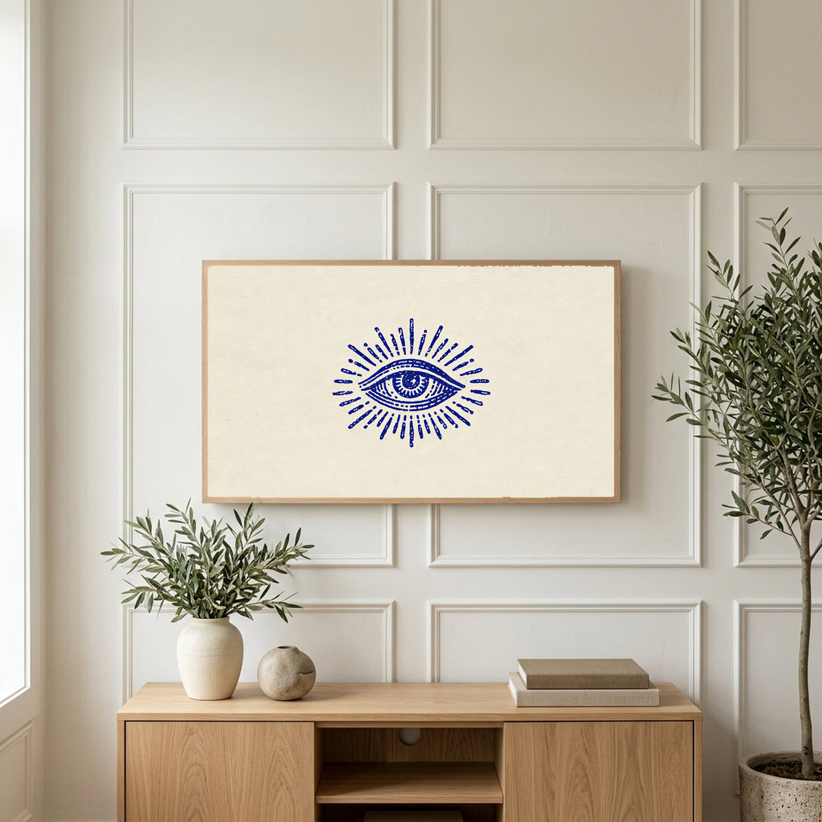 Mystic eye art on a TV above a light oak sideboard with olive branches in a bright living room
