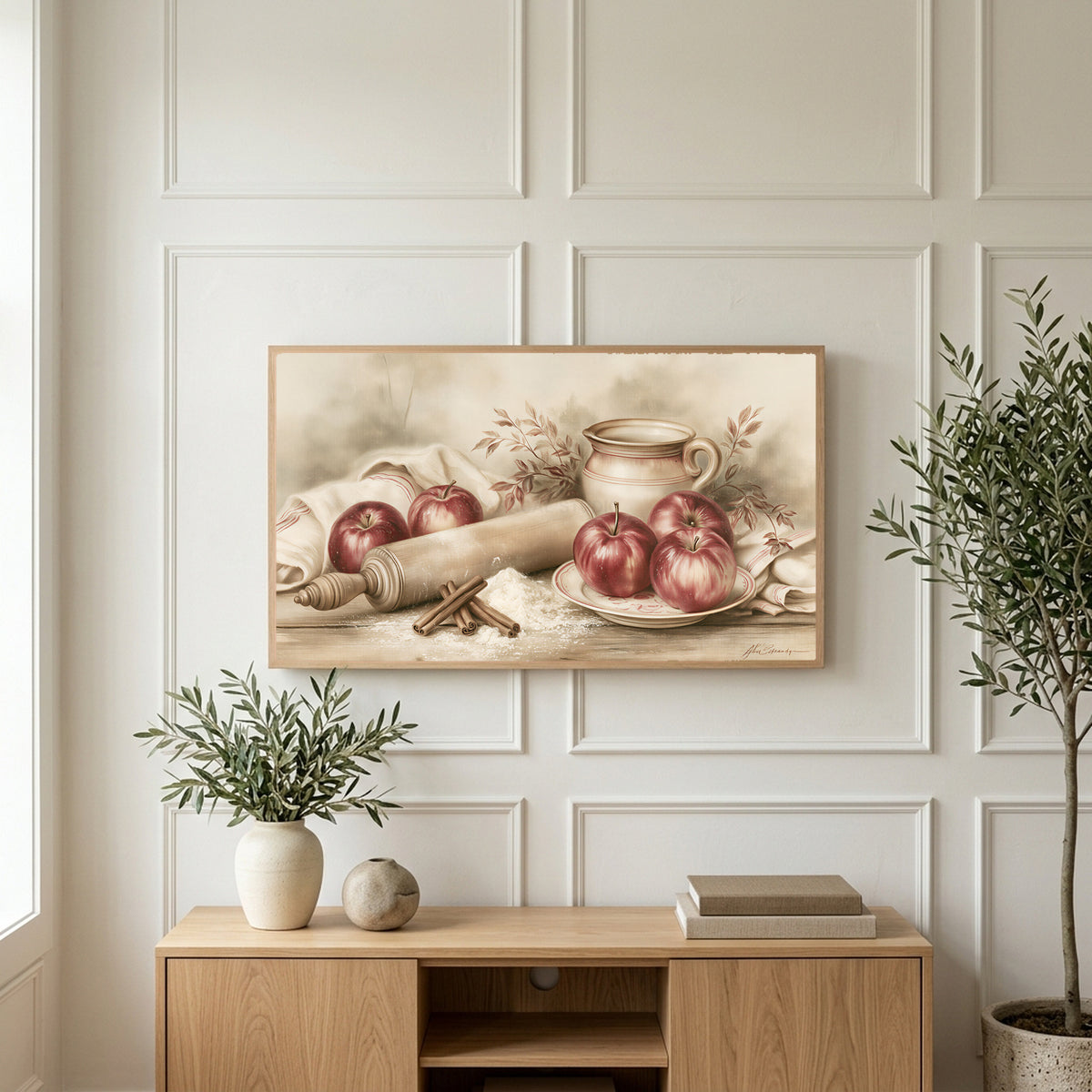 Farmhouse apples art on a TV above a light oak sideboard with olive branches in a bright living room