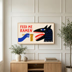 Feed Me Ramen art on a TV above a light oak sideboard with olive branches in a bright living room