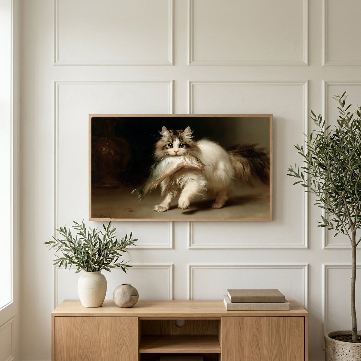 Kitten with a big fish art on a TV above a light oak sideboard with olive branches in a bright living room