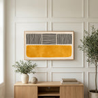 Abstract lines and color block art on a TV above a light oak sideboard with olive branches in a bright living room