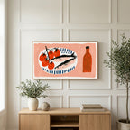 Sardines and tomatoes art on a TV above a light oak sideboard with olive branches in a bright living room