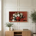 White lilies in a red vase art on a TV above a light oak sideboard with olive branches in a bright living room