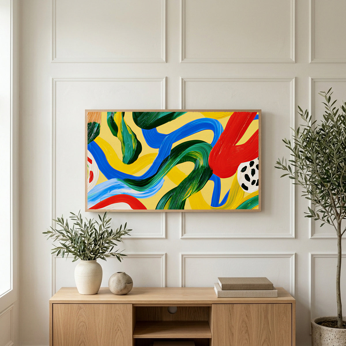 Colorful brushstroke loops art on a TV above a light oak sideboard with olive branches in a bright living room