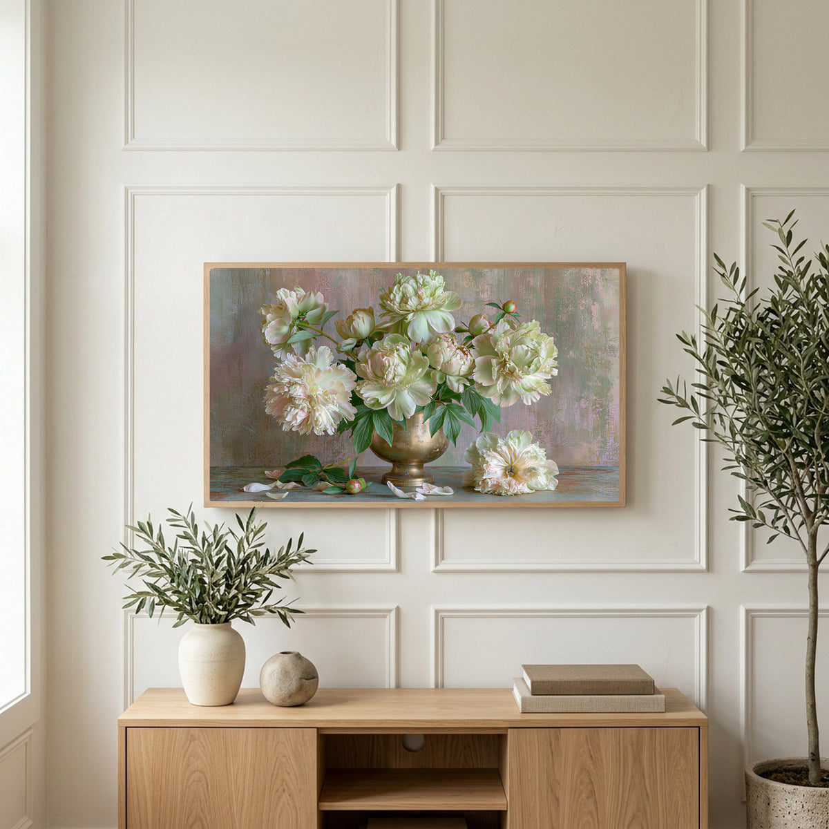 Peonies in a brass urn art on a TV above a light oak sideboard with olive branches in a bright living room