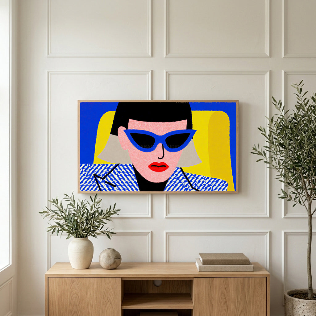Pop art woman in sunglasses art on a TV above a light oak sideboard with olive branches in a bright living room