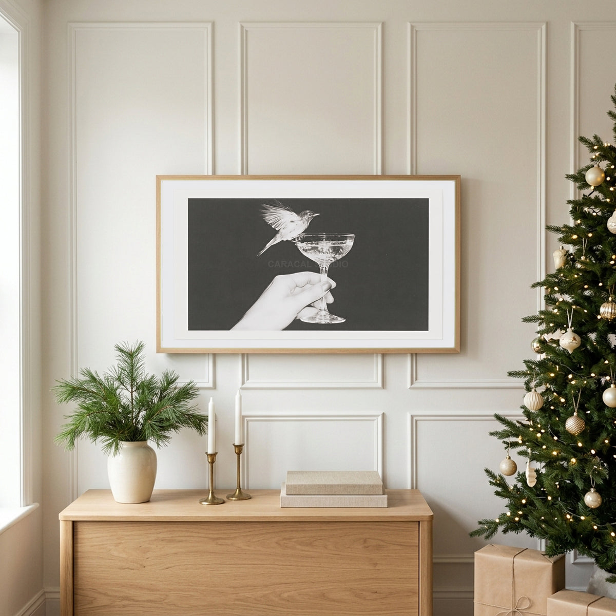 Bird and champagne glass TV art above an oak sideboard next to a decorated Christmas tree