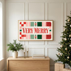 Very Merry typography TV art above an oak sideboard next to a decorated Christmas tree
