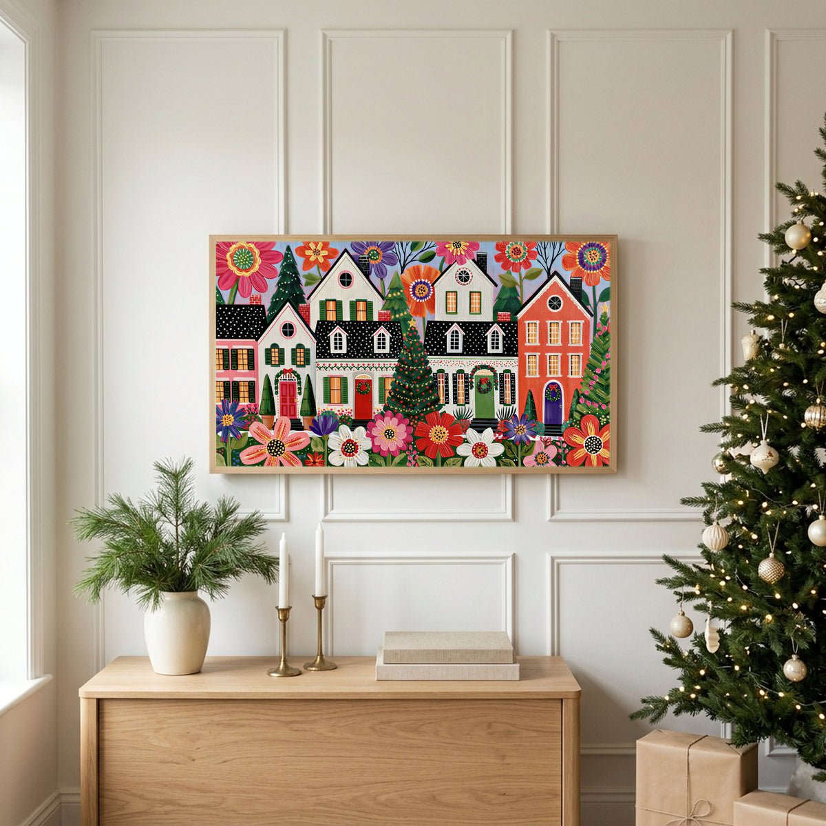 Folk art Christmas village TV art above an oak sideboard next to a decorated Christmas tree