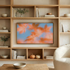 Autumn leaves art on a TV in built-in oak shelves with pumpkins and books