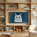 Cat eared ghost art on a TV in built-in oak shelves with pumpkins and books