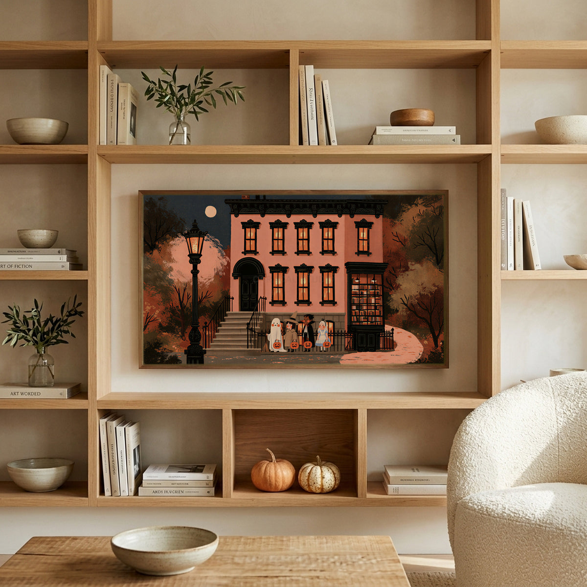 Trick or treat brownstone art on a TV in built-in oak shelves with pumpkins and books