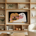Jack-o'-lantern and ghost art on a TV in built-in oak shelves with pumpkins and books