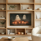 Two ghosts and jack-o'-lanterns art on a TV in built-in oak shelves with pumpkins and books