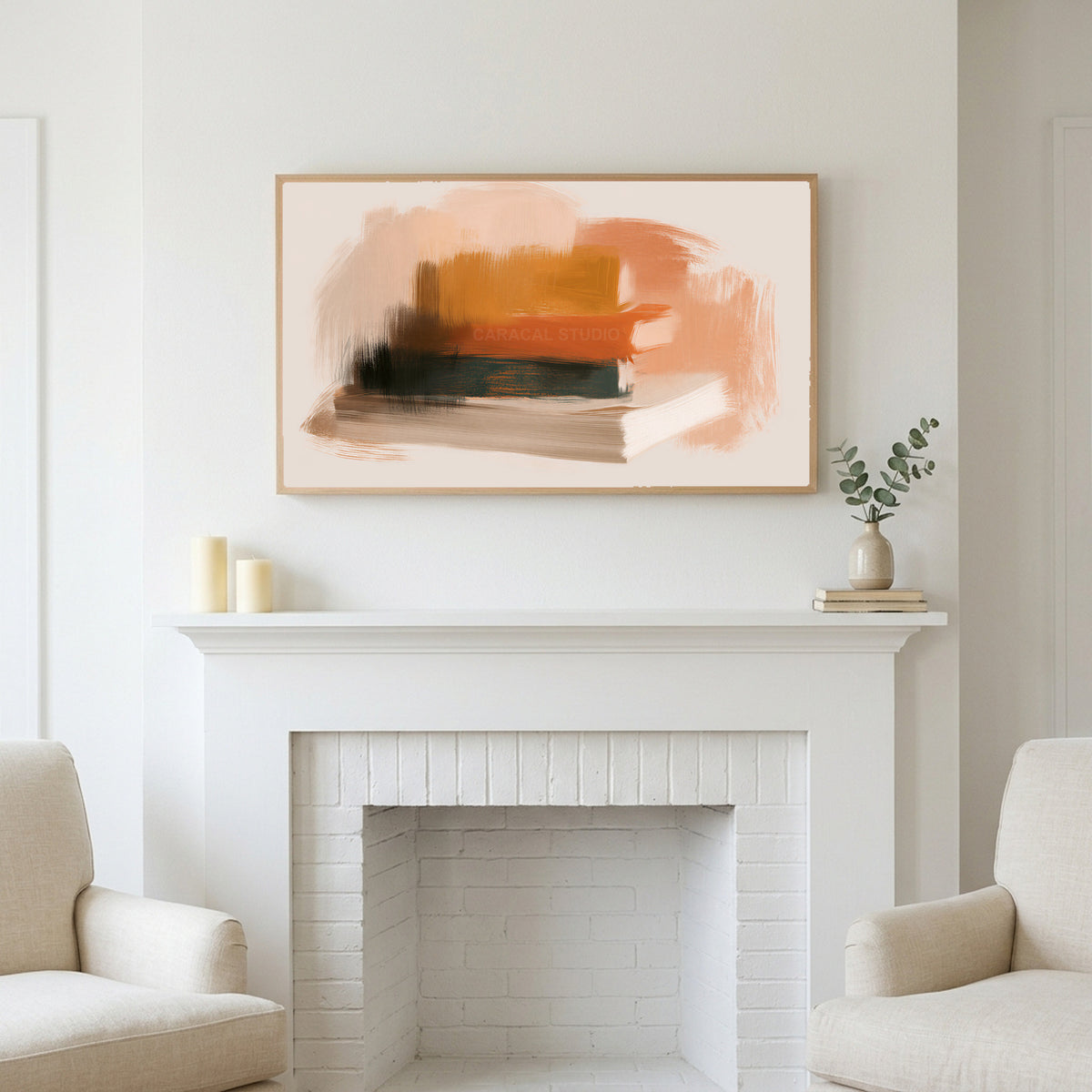 Book stack art above a white fireplace with candles and eucalyptus on the mantel