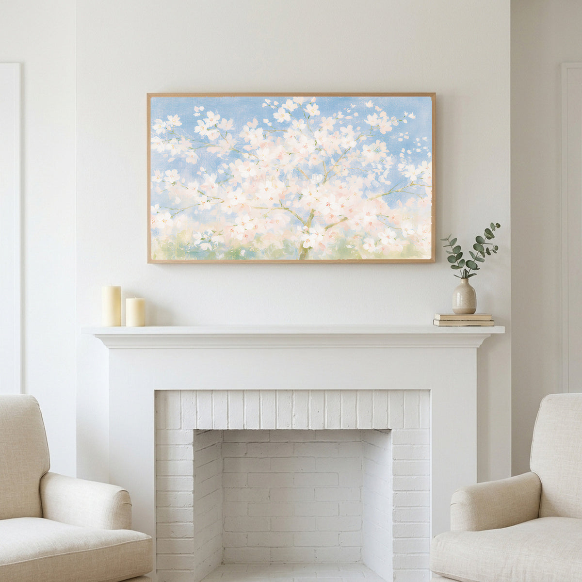 Cherry blossom tree art above a white fireplace with candles and eucalyptus on the mantel