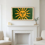 Woodblock sun art above a white fireplace with candles and eucalyptus on the mantel