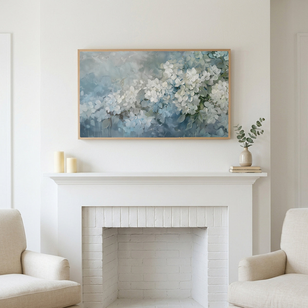 Frame TV art above a white fireplace with candles and eucalyptus on the mantel