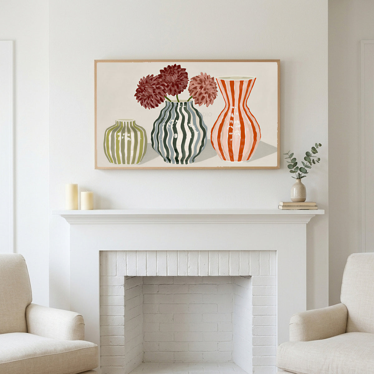 Frame TV art above a white fireplace with candles and eucalyptus on the mantel