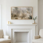 Misty meadow art above a white fireplace with candles and eucalyptus on the mantel
