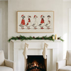 Geese in Santa hats art on a TV above a white fireplace with a pine garland and cream stockings
