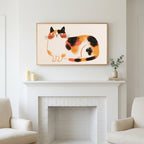 Calico cat art above a white fireplace with candles and eucalyptus on the mantel
