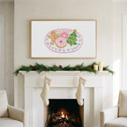 Christmas cookies art on a TV above a white fireplace with a pine garland and cream stockings