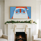 Santa face art on a TV above a white fireplace with a pine garland and cream stockings
